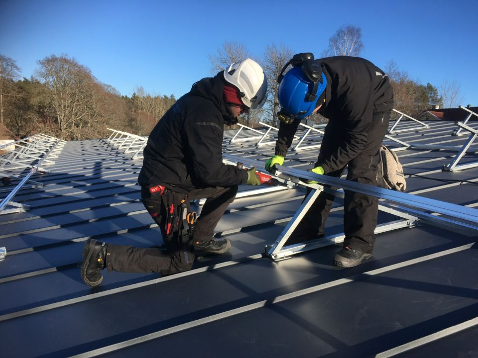Työmiehet asentavat aurinkosähköjärjestelmää